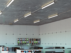 Modern office space with desks, computers, chairs, and shelves of colorful binders, all brightly lit by TU Tube Light Single 20W 4 overhead.