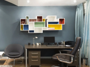 Modern home office featuring a desk, computer, black chair, round gray chair, and colorful geometric wall shelves against a blue wall, all brightly illuminated by the TU Tube Light Double 40W 4.