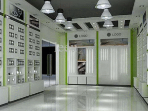 Modern showroom interior featuring glossy tiled floors, display shelves, green accents, and overhead pendant lights with BLAZ LED Bulb 60W; large glass double doors are visible in the background.