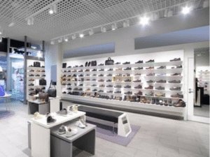 A modern shoe store interior with shelves of footwear, a central bench, and bright overhead lighting from BLAZ LED Bulb 40W.